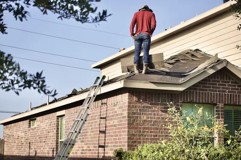 Professional roofer working on a residential roof in Kirtland
